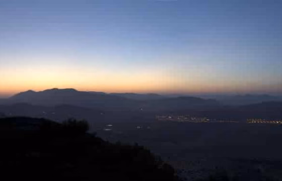 Atardecer anaranjado sobre la silueta de una montaña