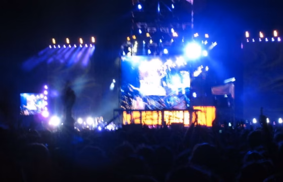 Público de un concierto con el escenario iluminado de azul