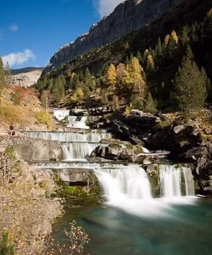 Cascada entre rocas en un bosque otoñal