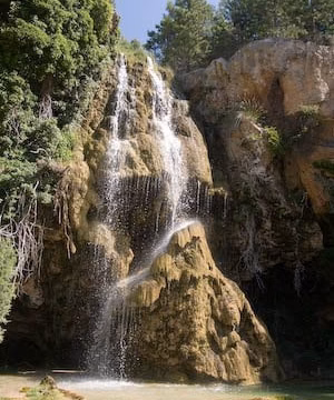 Cascada entre rocas y vegetación en un barranco