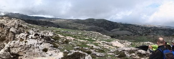 Grupo de senderistas descansando en una cresta rocosa panorámica