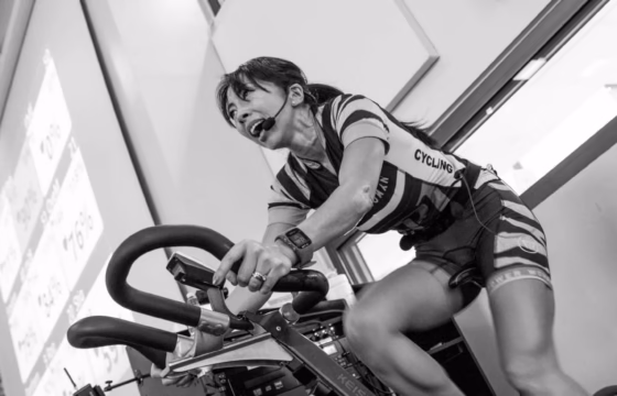 Foto en blanco y negro de una persona en una bicicleta estática antigua