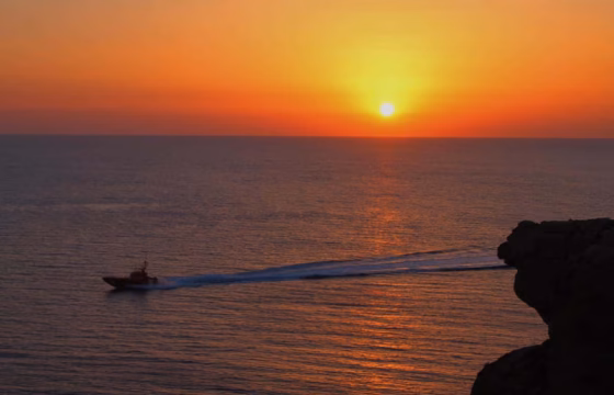 Atardecer sobre el mar con una formación rocosa