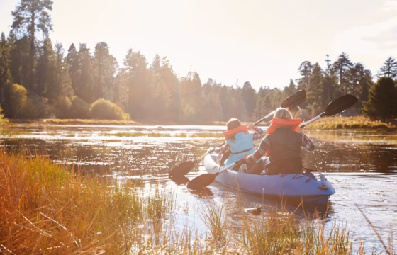 Familia en una balsa remando por un río al atardecer