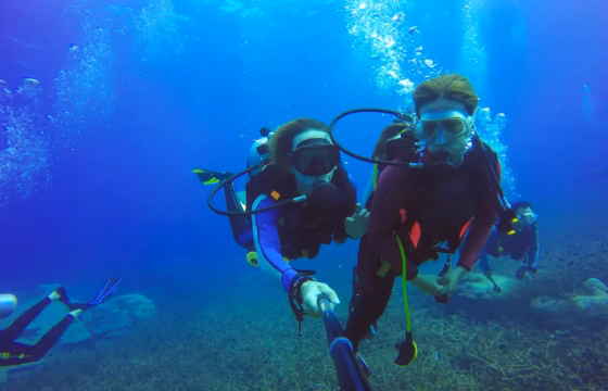 Dos buceadores en aguas azules profundas
