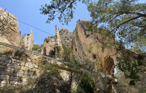 Formaciones rocosas verticales y afiladas con un cable de seguridad instalado en la pared junto al sendero
