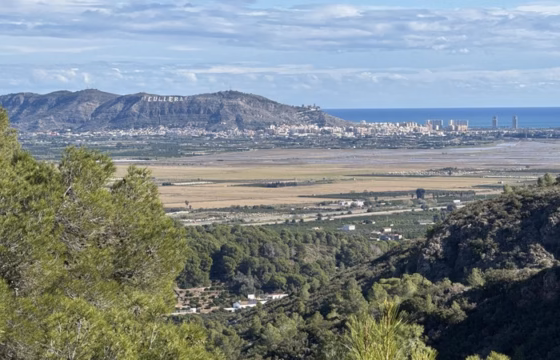 Vista panoramica de la marjal y la costa con el nombre CULLERA escrito en la ladera de una montana y el mar Mediterraneo al fondo